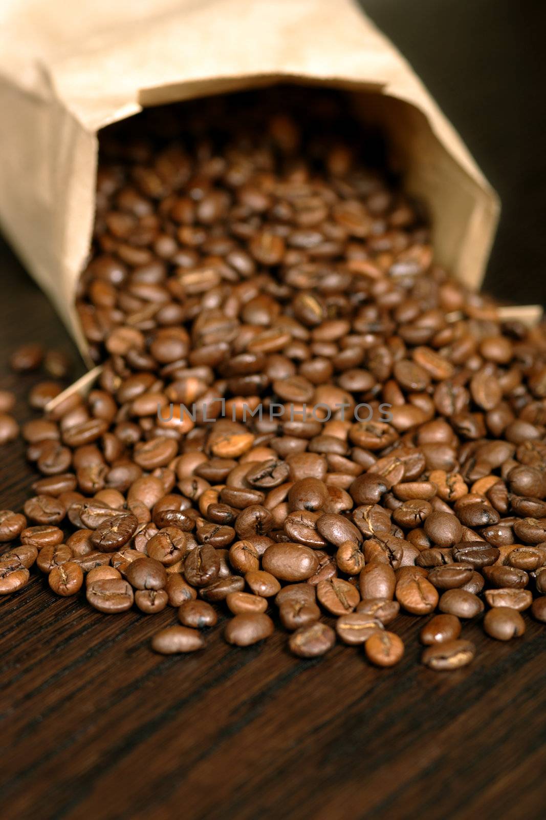 Coffee beans spilling from a paper bag.
