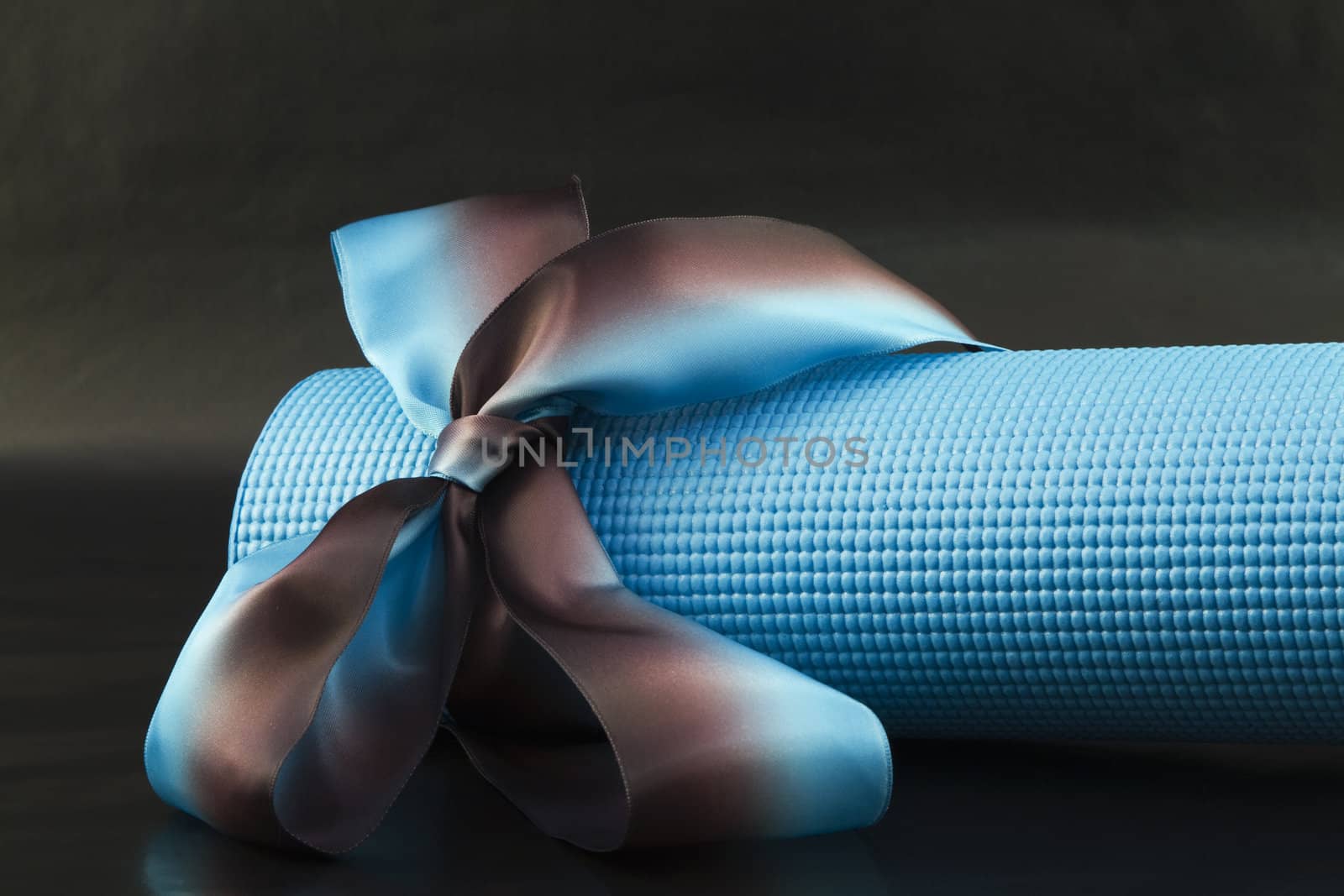 Blue yoga with a blue and brown ribbon on a black background is a sharing of yoga's pleasures