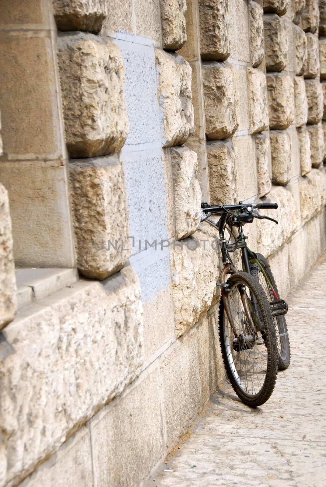 one black bicycle by building stone wall in Italy, Trieste