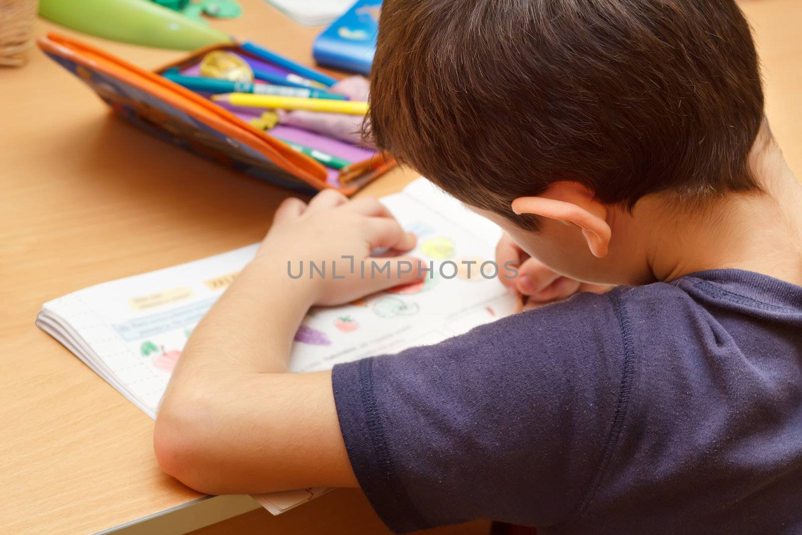 boy doing homework  with color pencil, painting fruits