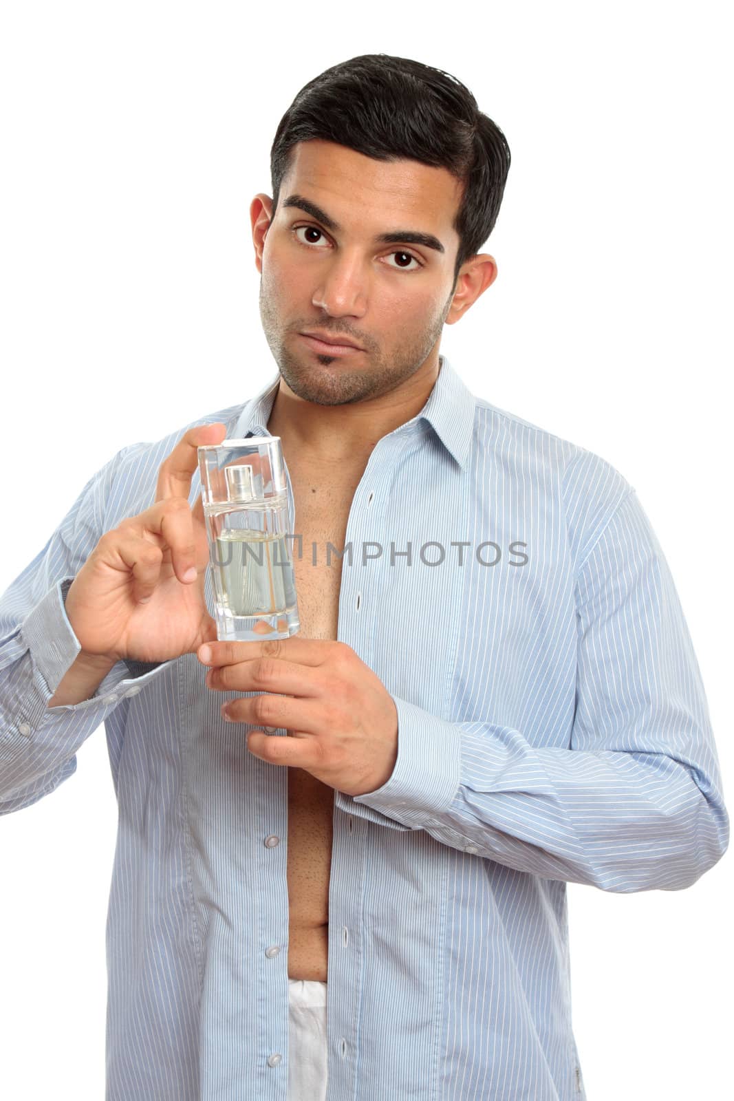 A Handsome man holding a  bottled perfume cosmetic in his hand.  White bavkground.