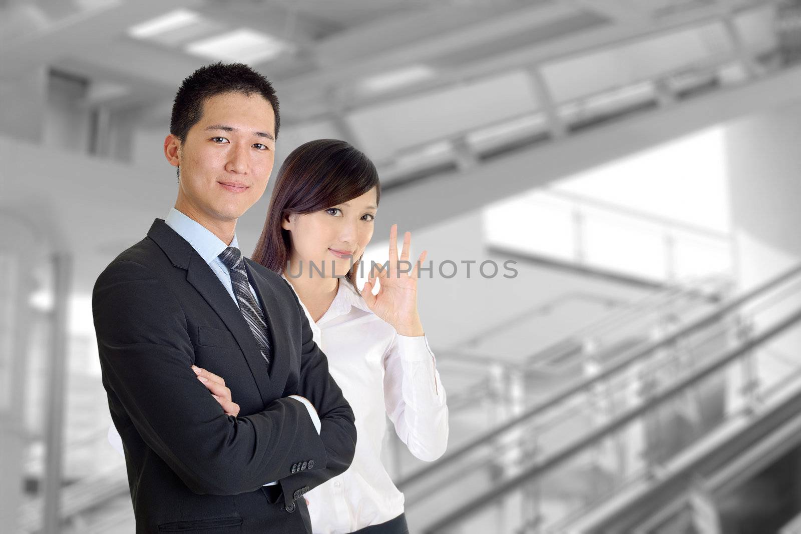 Business team, smiling businessman and friendly businesswoman in modern building.