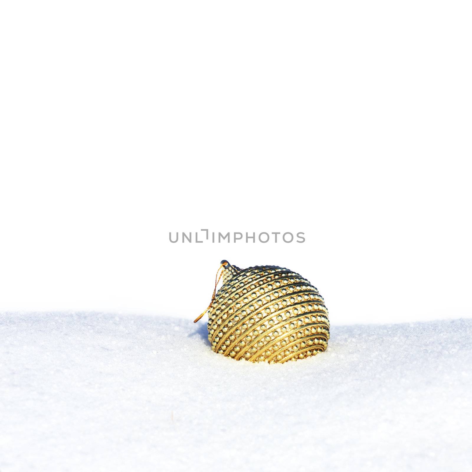 golden christmas bauble in snow