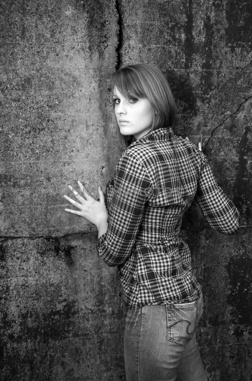 A beautiful young woman posing against a wall