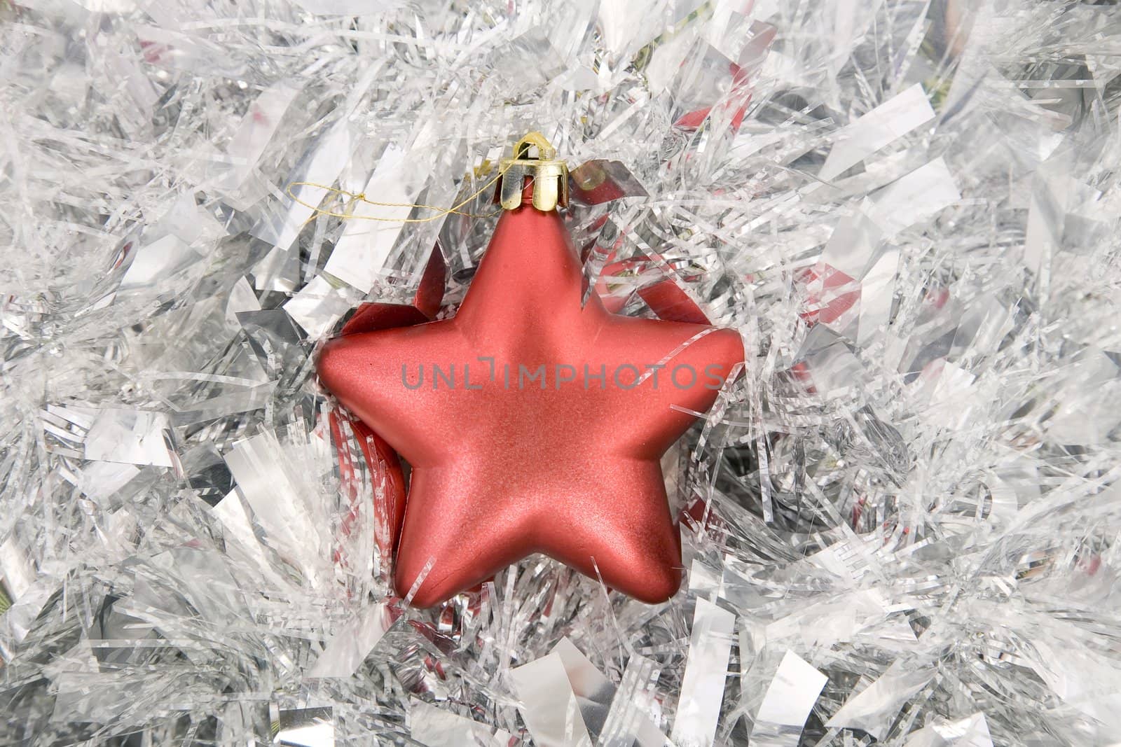 front view of red star, christmas decoration on silver tinsel