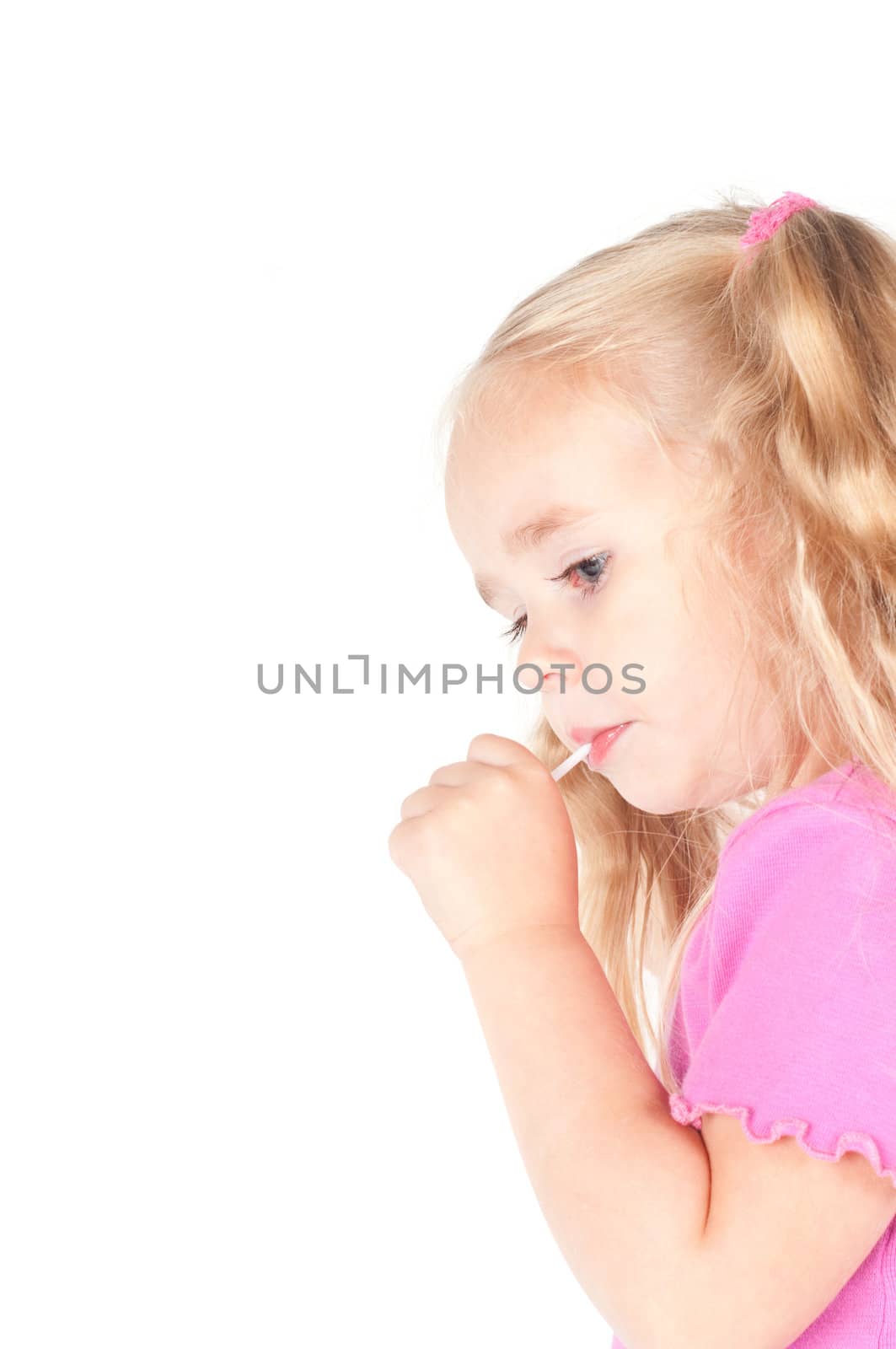 Little cute girl in pink and with ponytails in studio