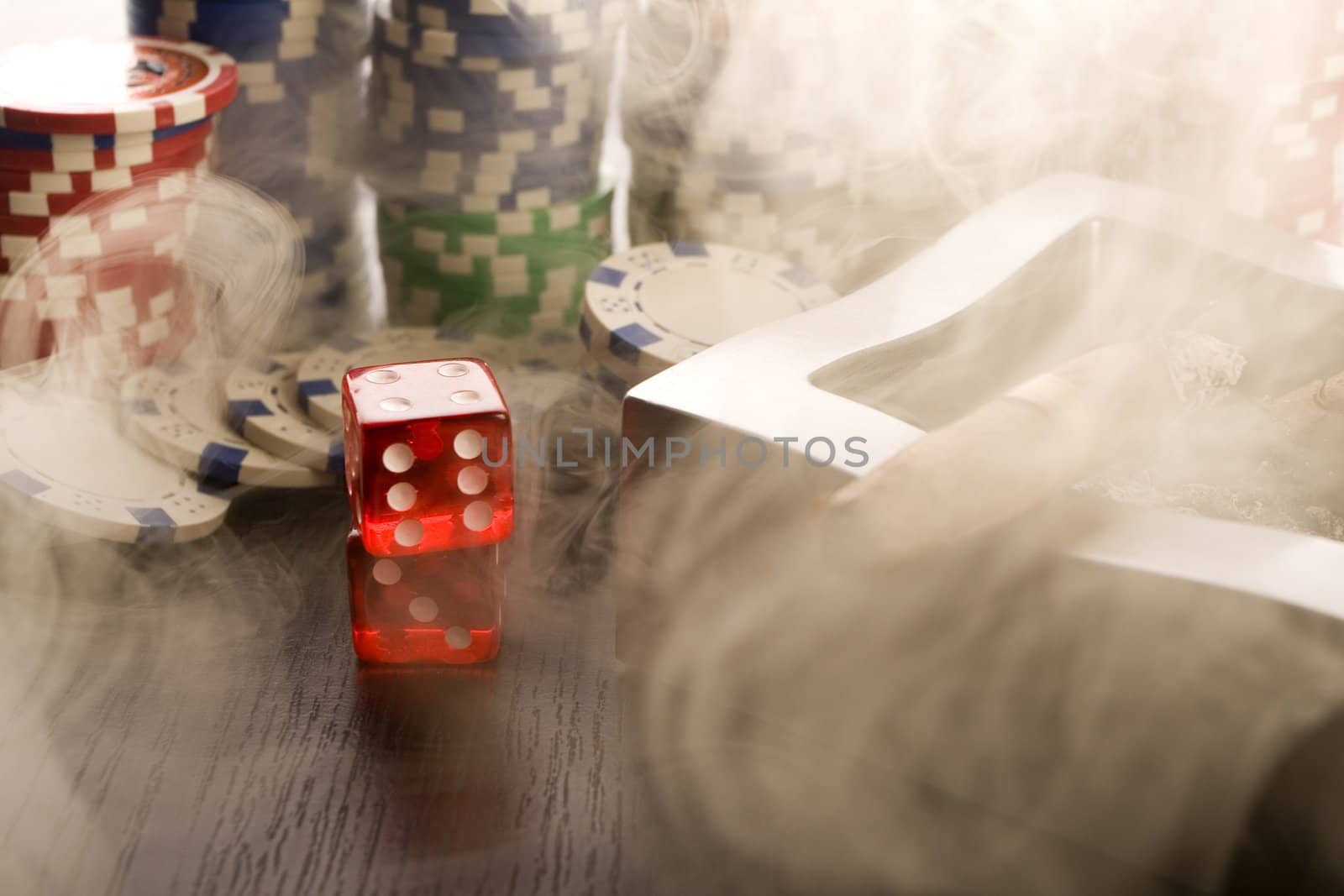 Gambling chips and casino dice on brown mat