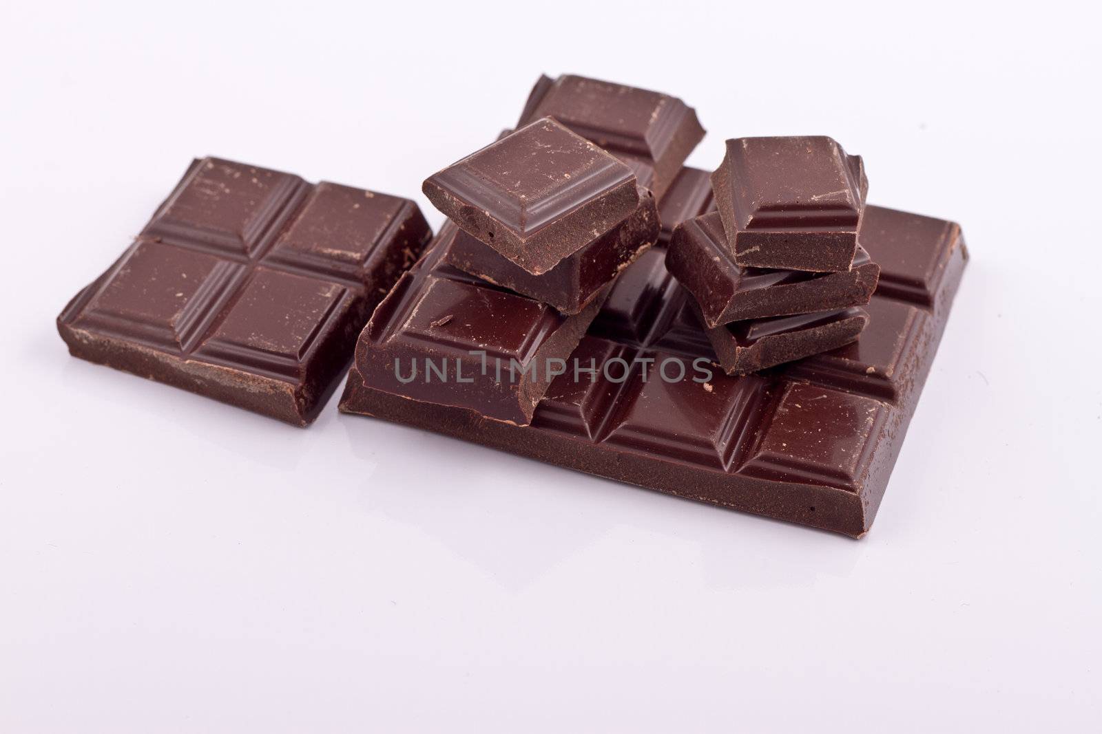 Stacked cholate pieces on white background