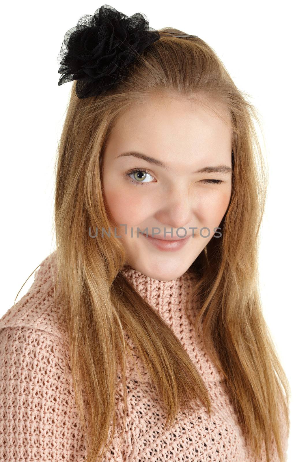 Playful young girl winks at us on a white background
