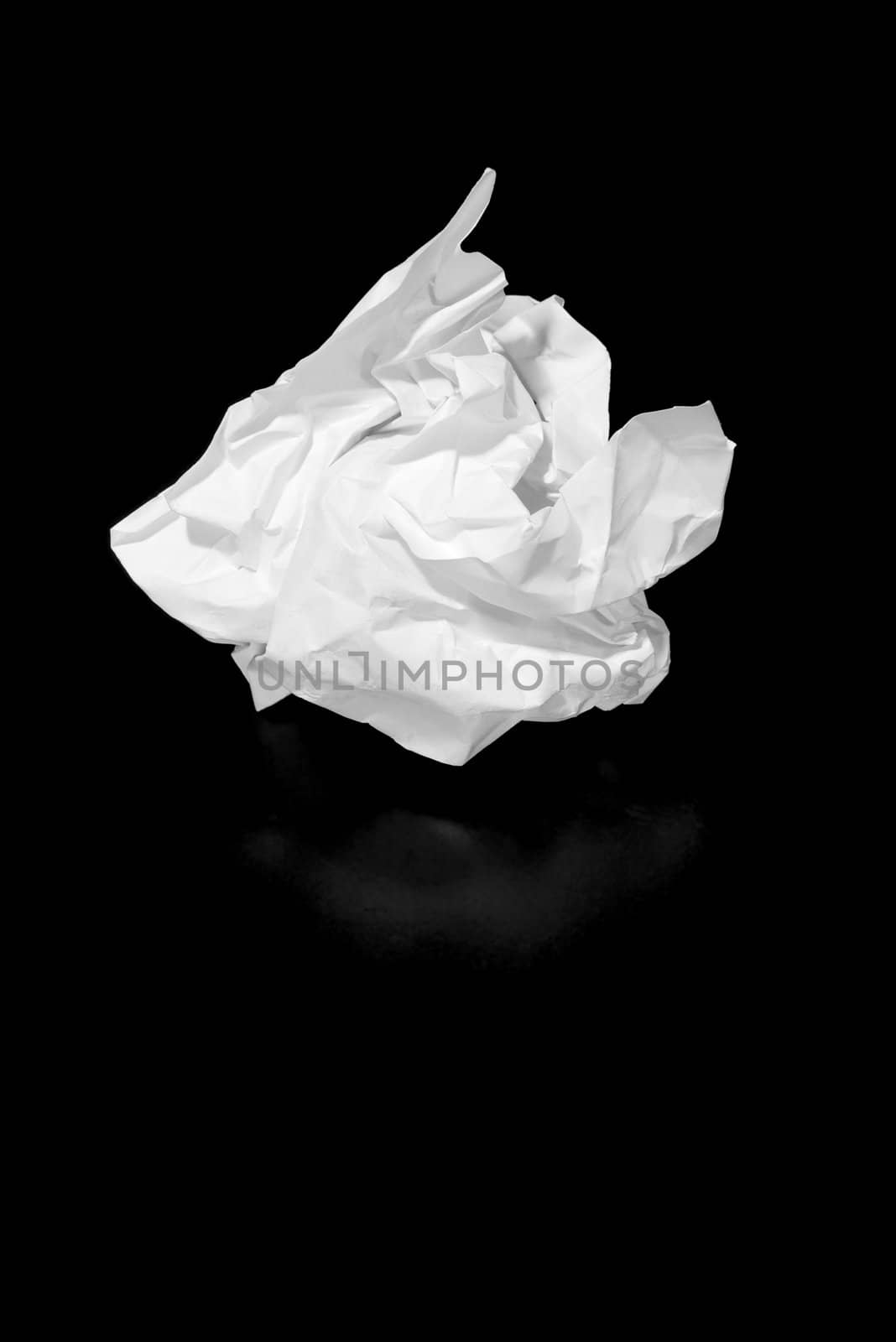 A piece of discarded paper isolated on black