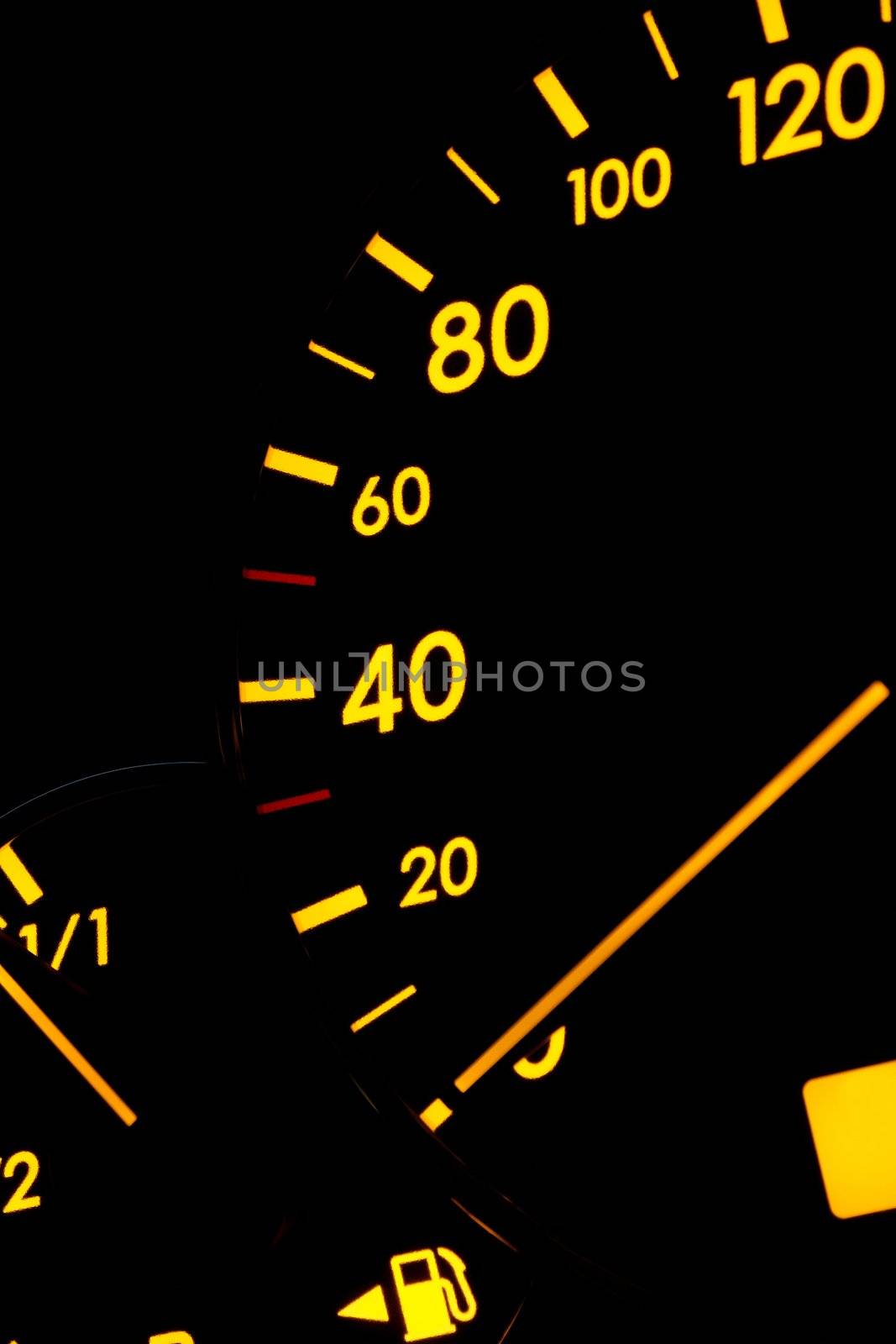 Speedometer of a car glowing against black background