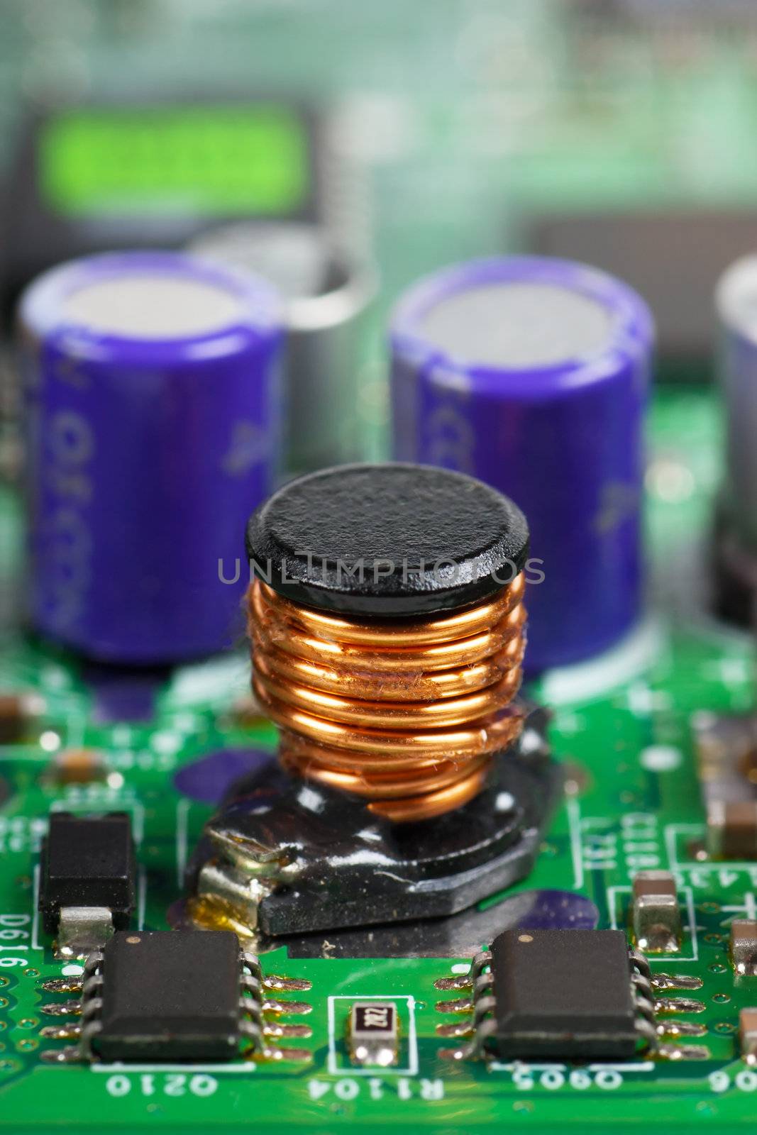Macro view of electronic cicuit board with induction coil foreground