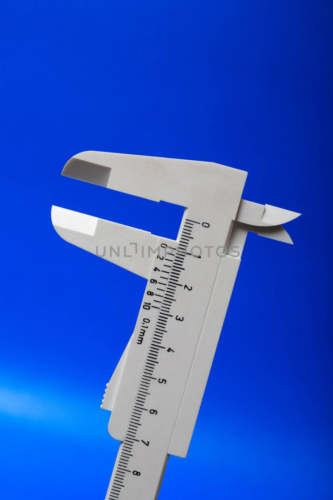 Closeup of gray plastic sliding callipers isolated on blue background
