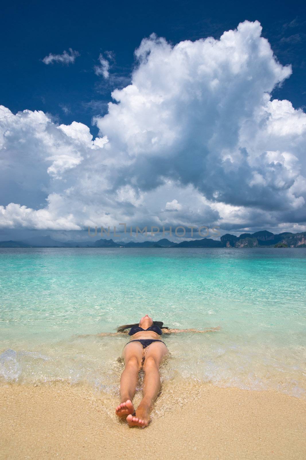 Woman lying in the turquoise sea and taking sunbath