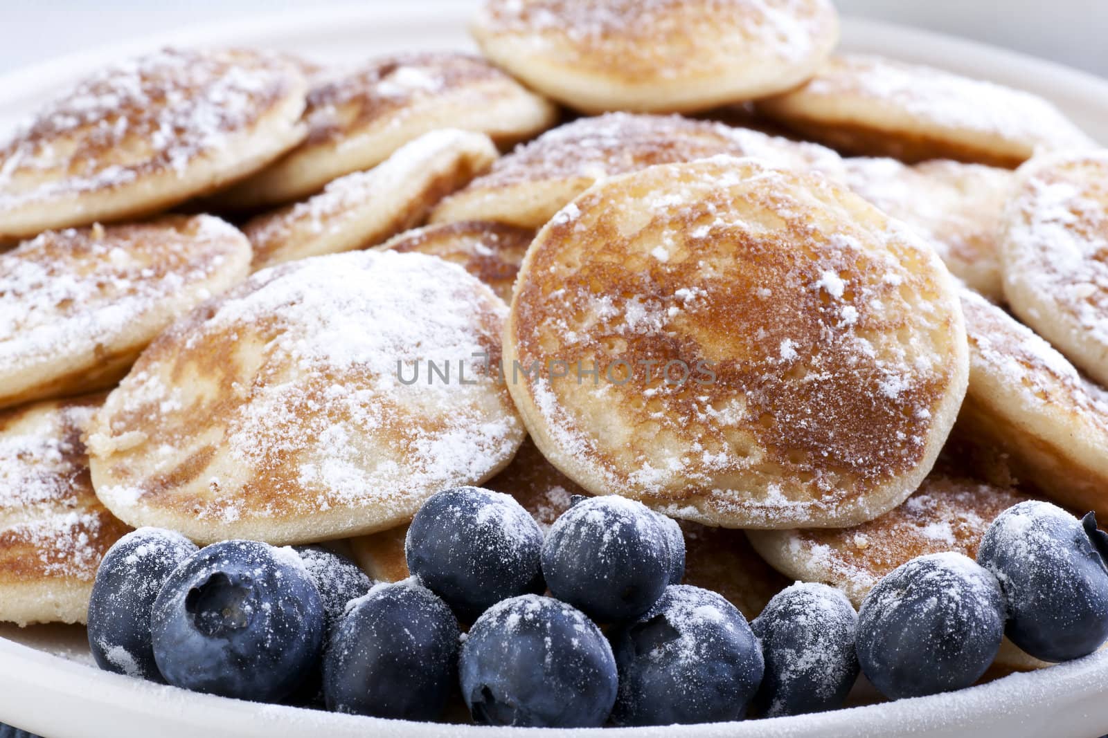 Dutch mini pancakes, or poffertjes, and fresh blueberries sprinkled with powdered sugar.