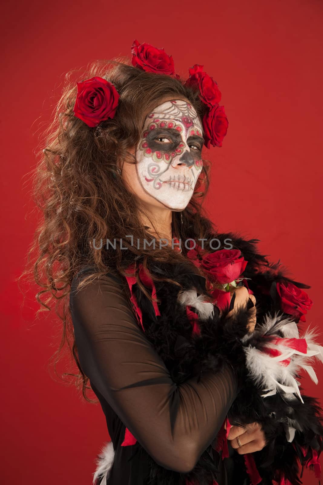 A beutiful woman holding roses and wearing zombie makeup for All Souls Day