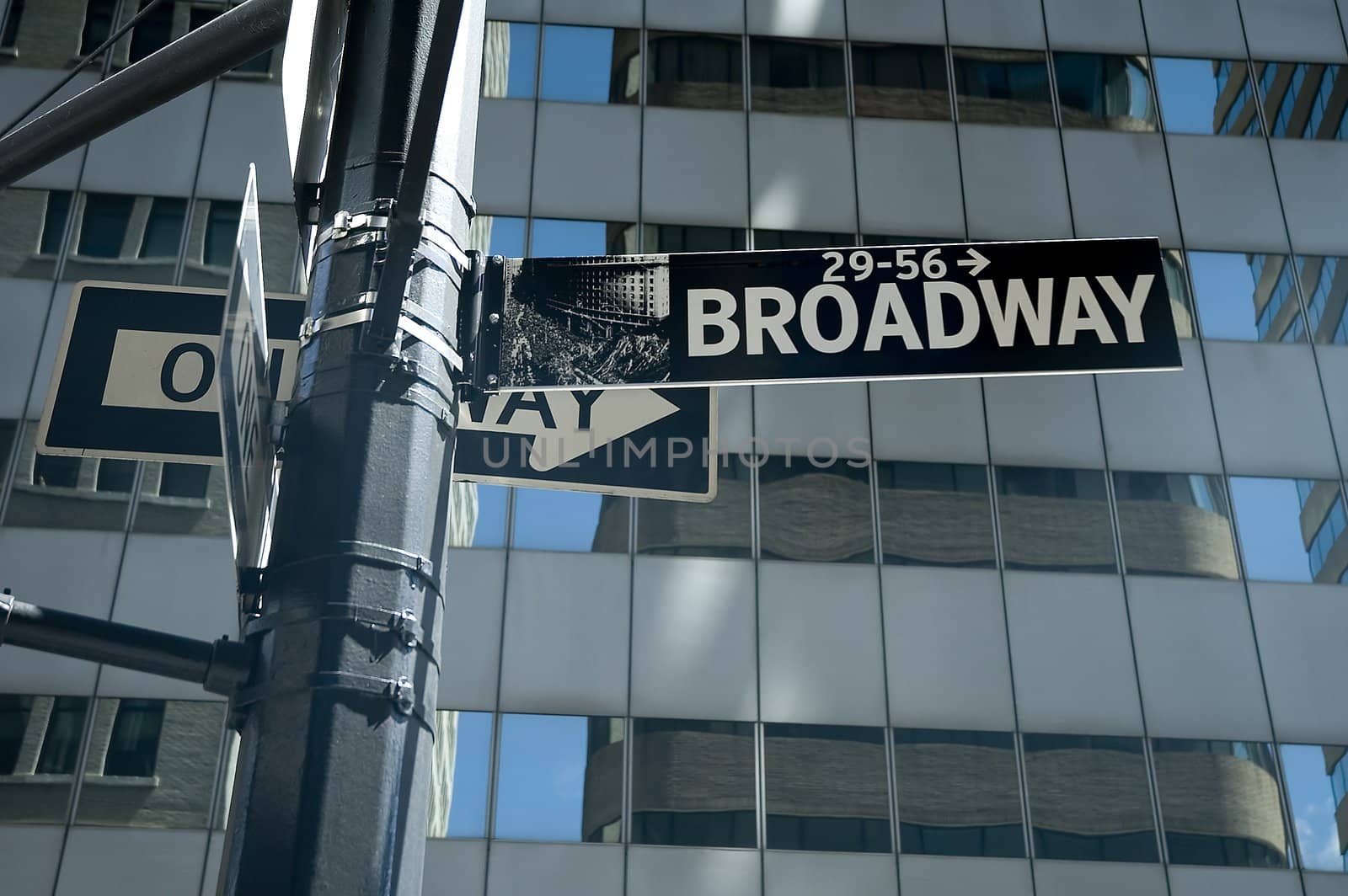 broadway and one way sign, modern architecture in background