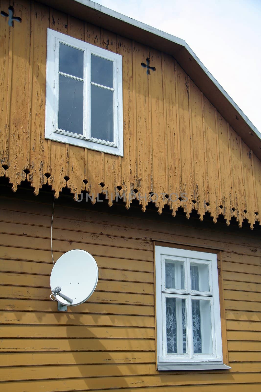 white satellite on old wooden house, contrast between modern and historical