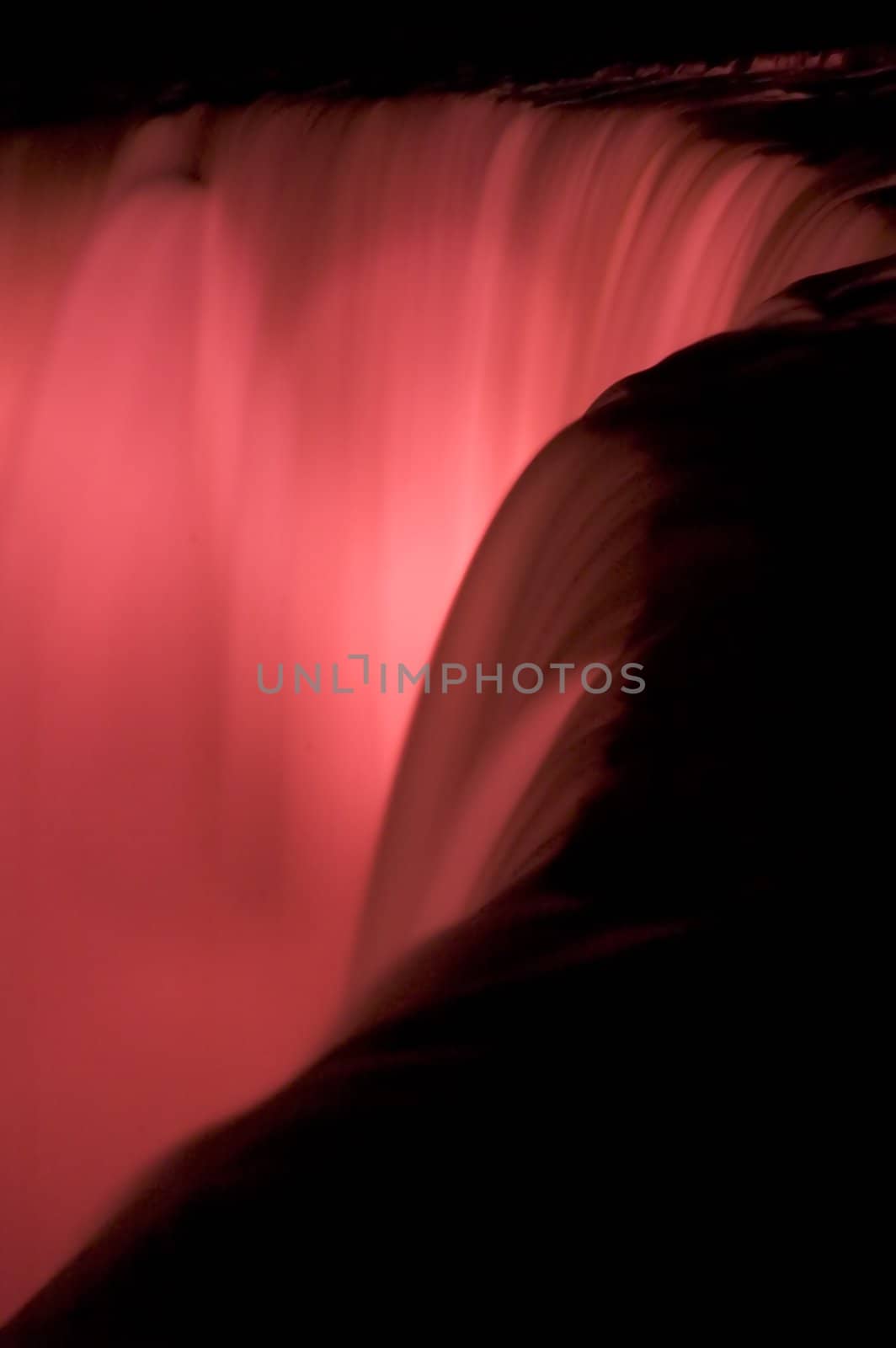 detail abstract photo of niagara falls at night, lighted with red color 