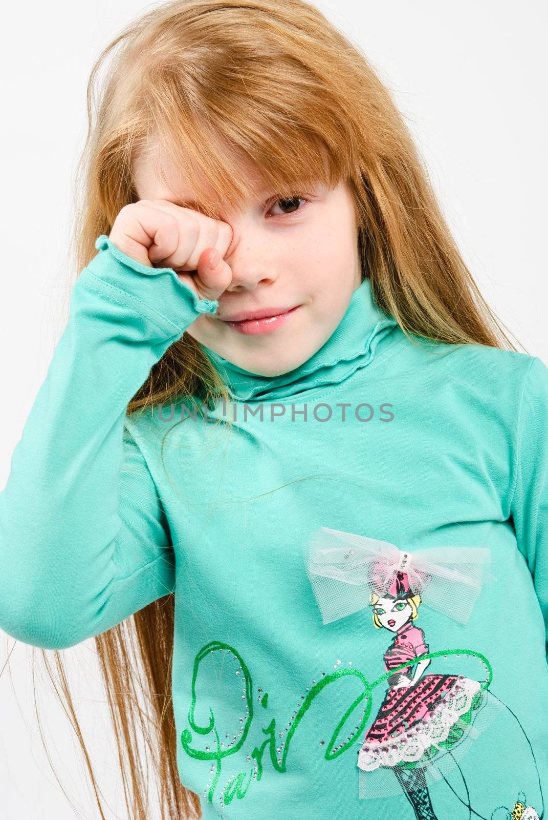 studio shot of pretty little girl rubbing eyes with hand