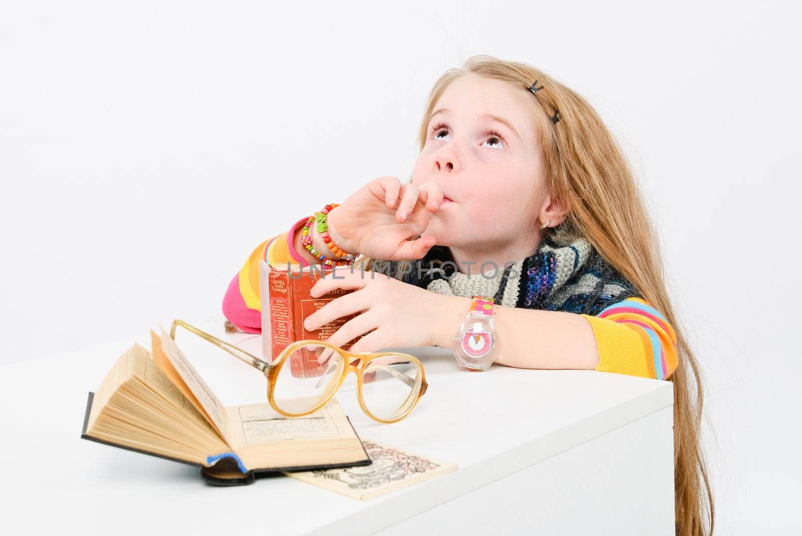 studio shot of pretty little girl reading a book