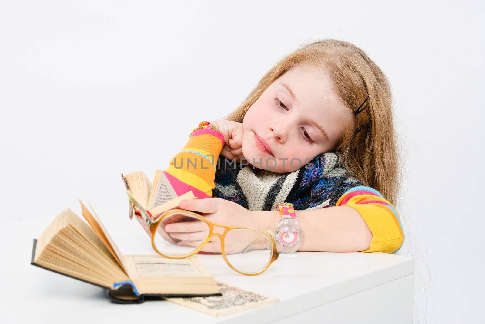 studio shot of pretty little girl reading a book