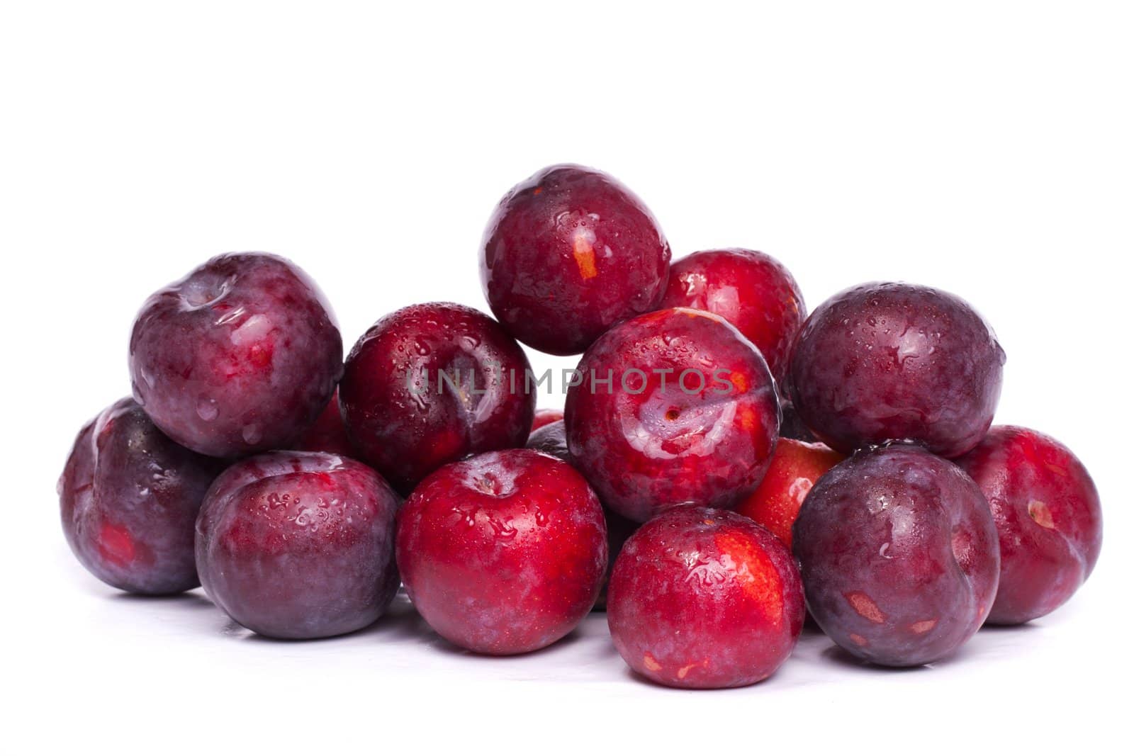 Close up view of a bunch of fresh red and violet plums isolated on a white background.
