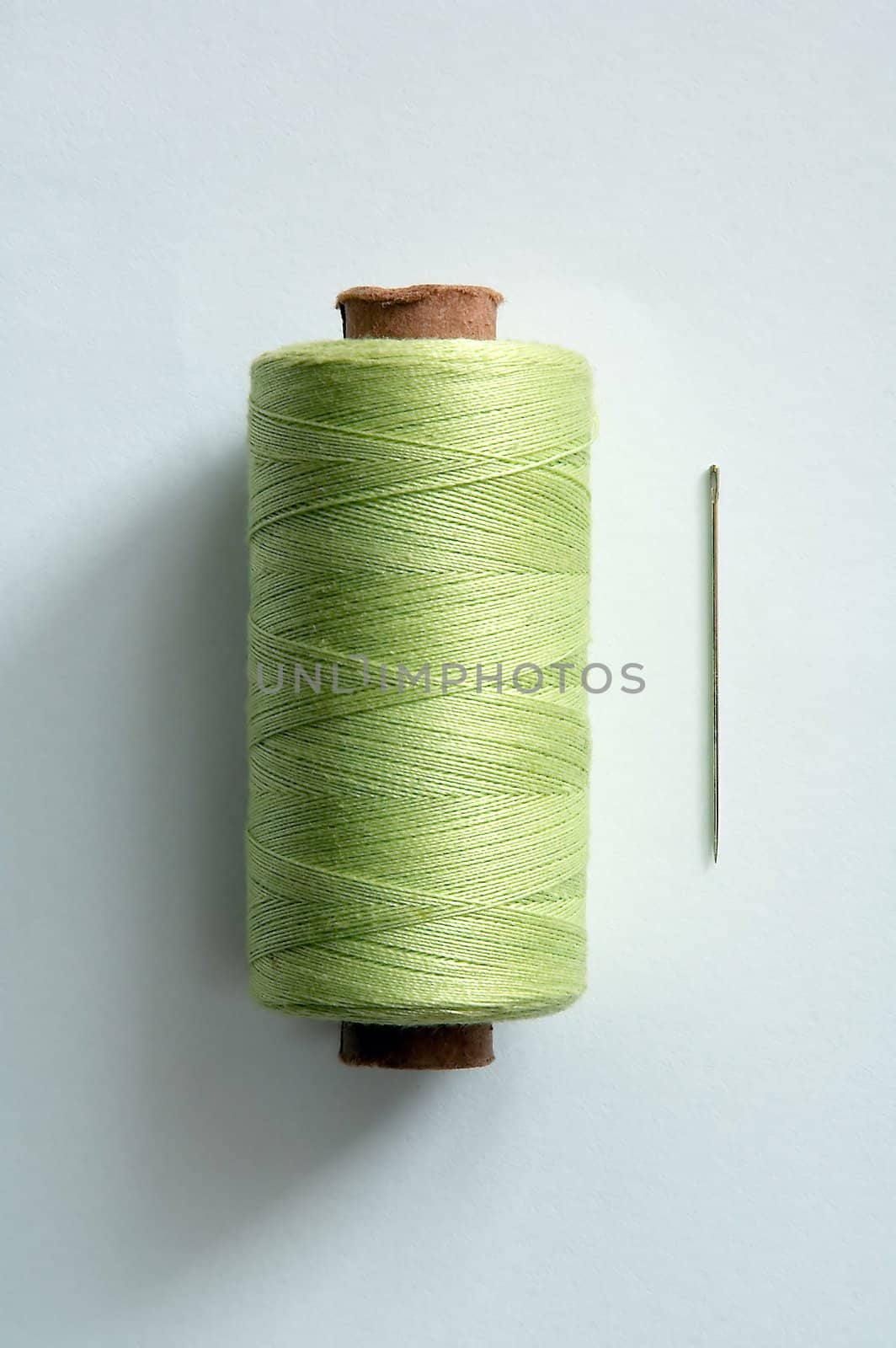 small needle and light green fibre on white background