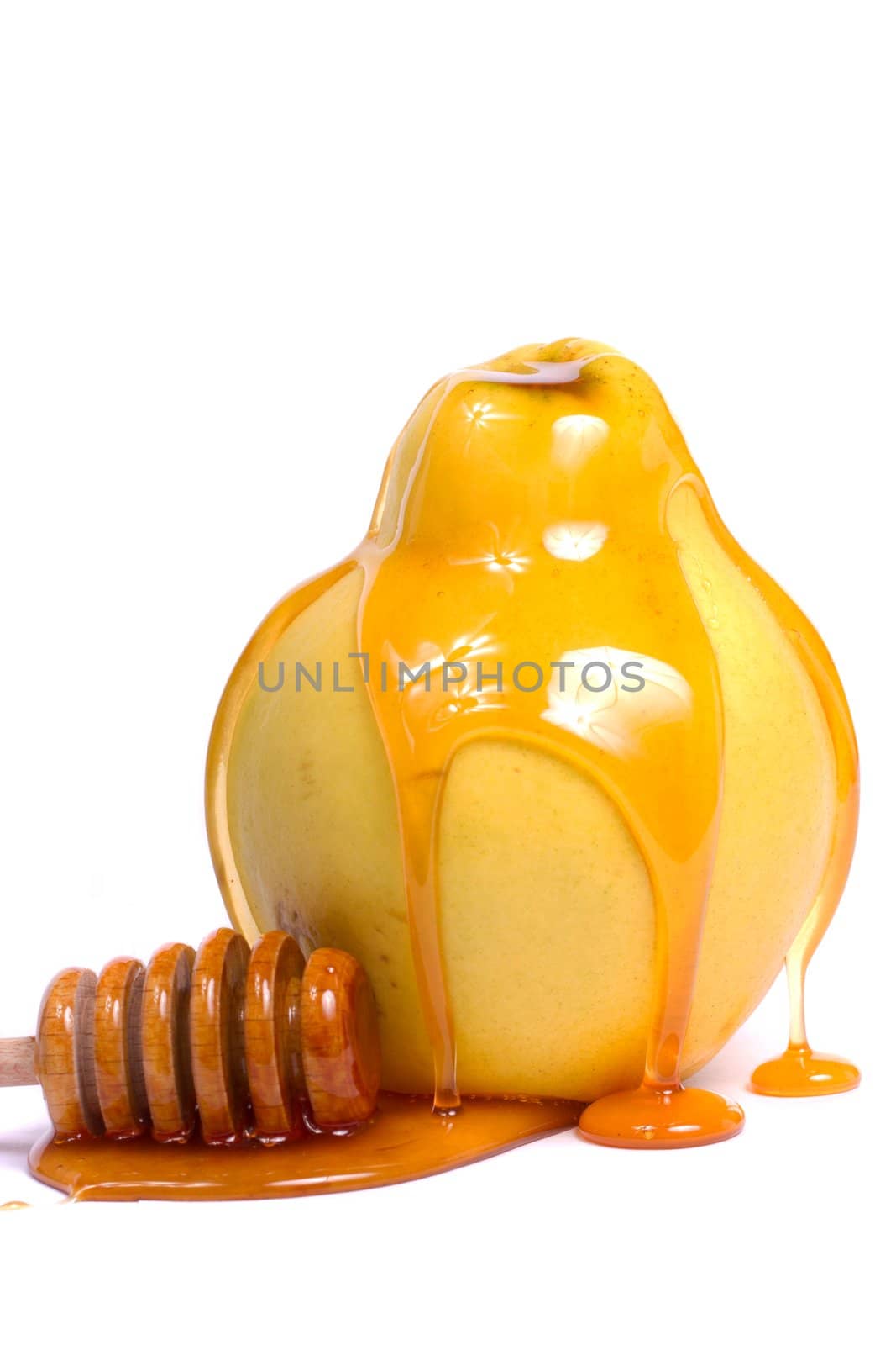 Close up view of a quince fruit with a honey dipper isolated on a white background.