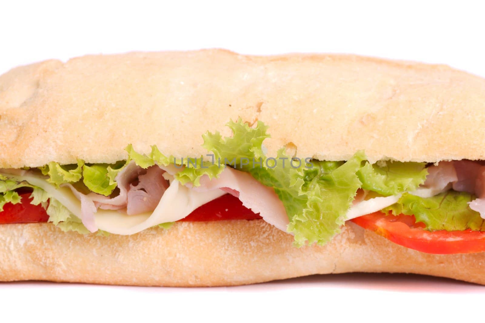 Close view of a fresh tasty ciabatta sandwich with tomato, lettuce, cheese and ham isolated on a white background.