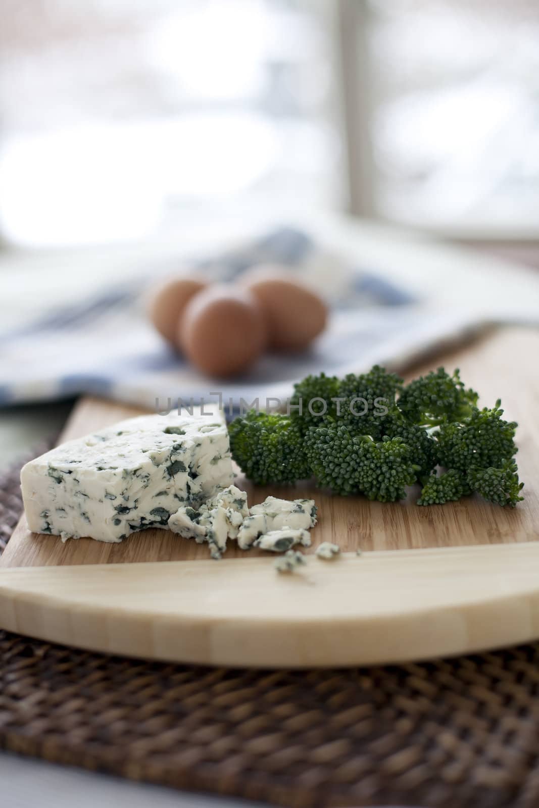 Fresh broccoli, blue cheese, and eggs; ingredients for a quiche.