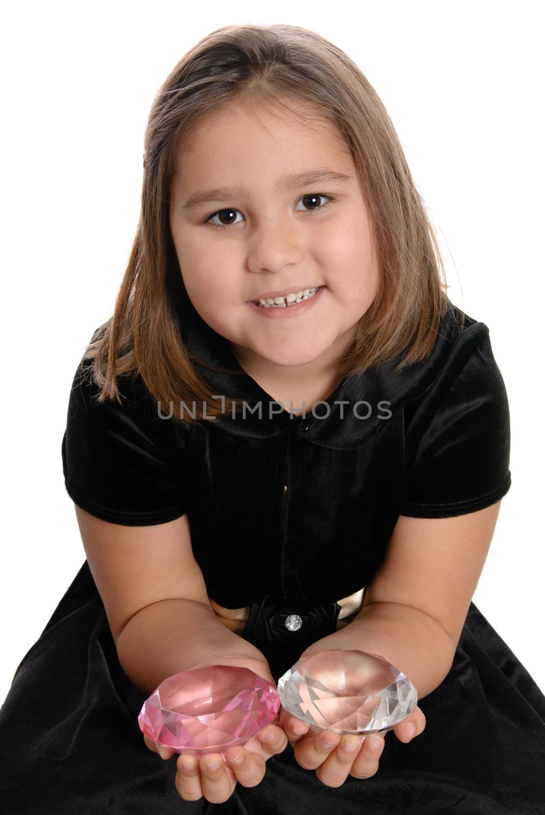 A spoiled girl is holding two large diamonds in her hands, isolated against a white background.