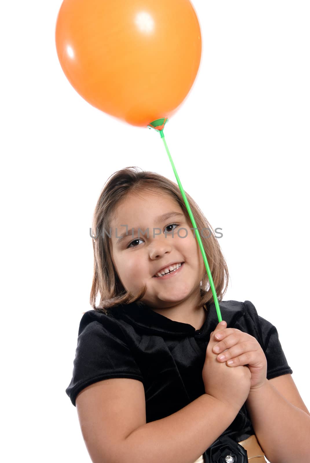 A cute and smiling five year old kindergartener is holding a balloon on a stick, isolated on a white background.