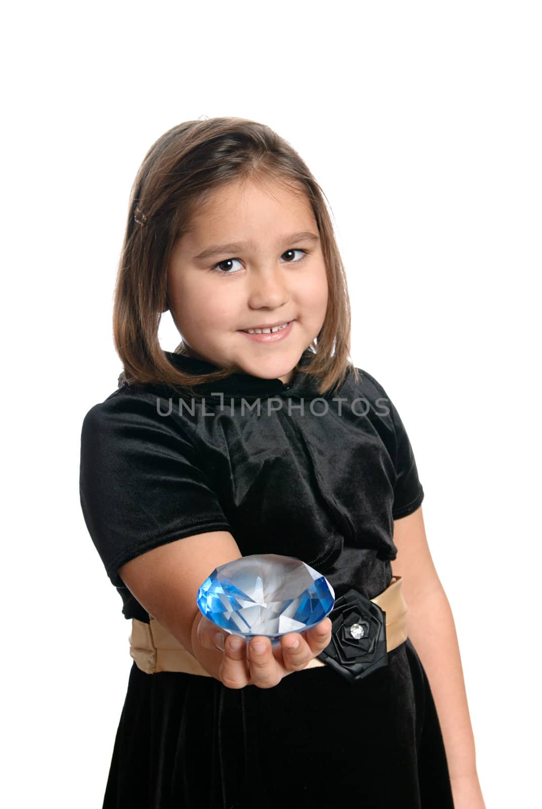 A cute little girl is holding out a blue diamond, isolated against a white background.