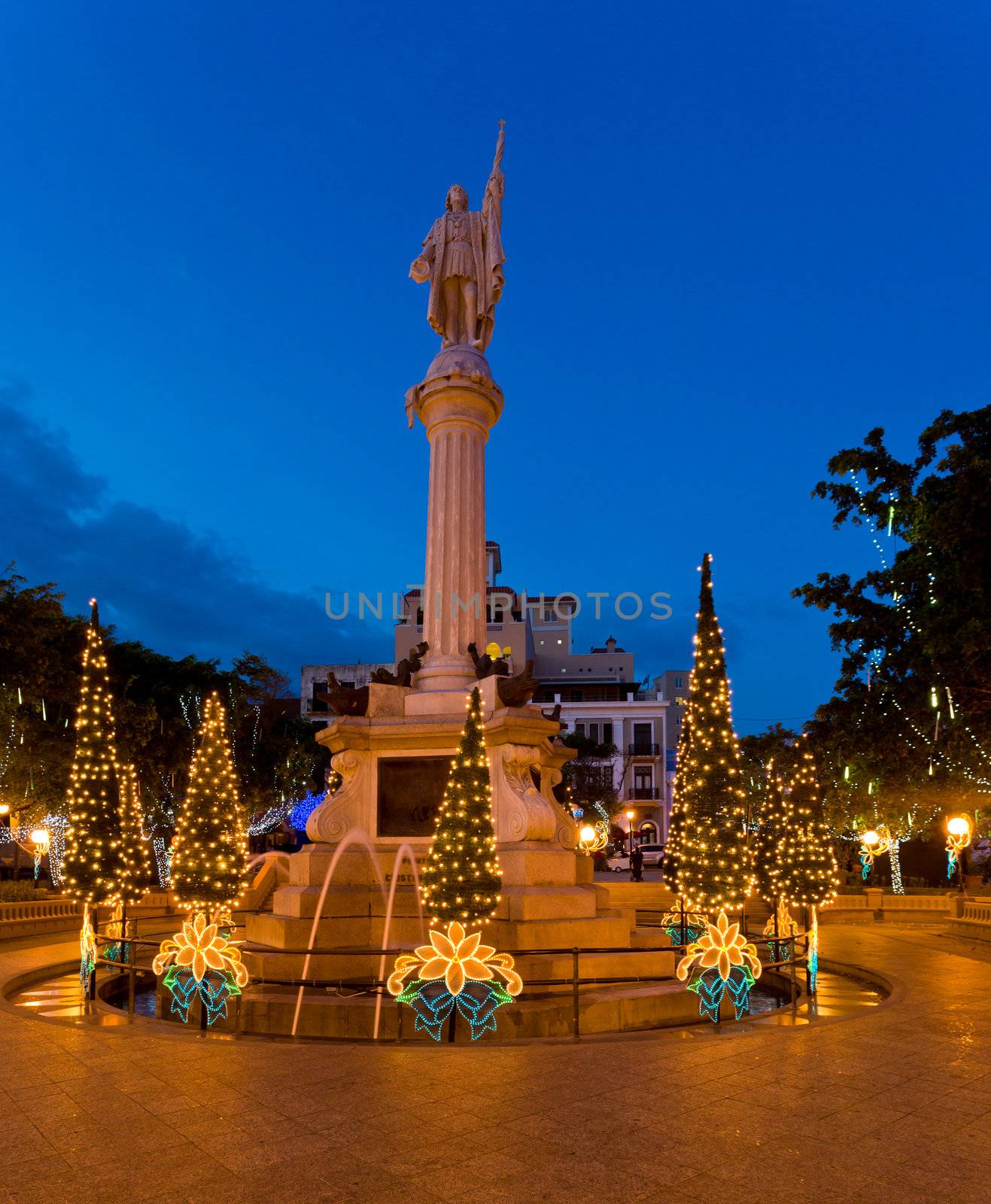Plaza Colon in old San Juan with statue of Cristobol Colon surrounded by xmas trees and illuminations