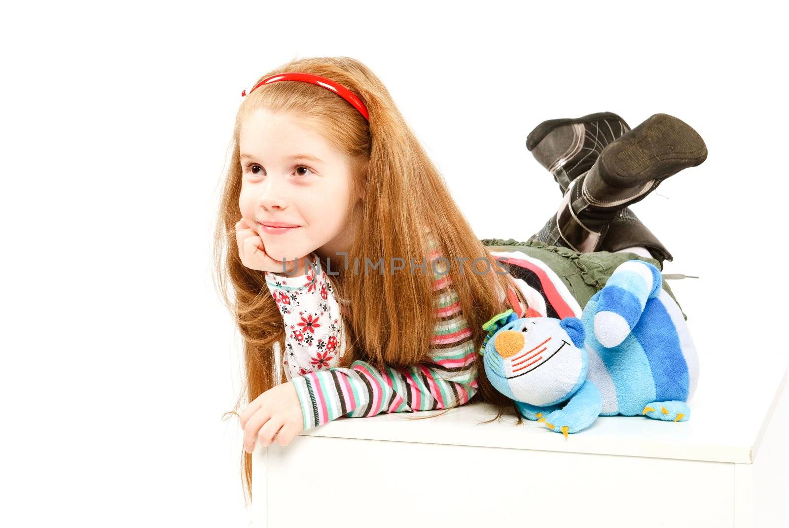 studio shot of lying  pretty little girl with blue cat toy