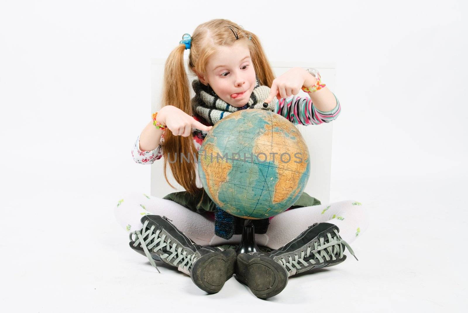 studio shot of pretty little girl staring at the globe