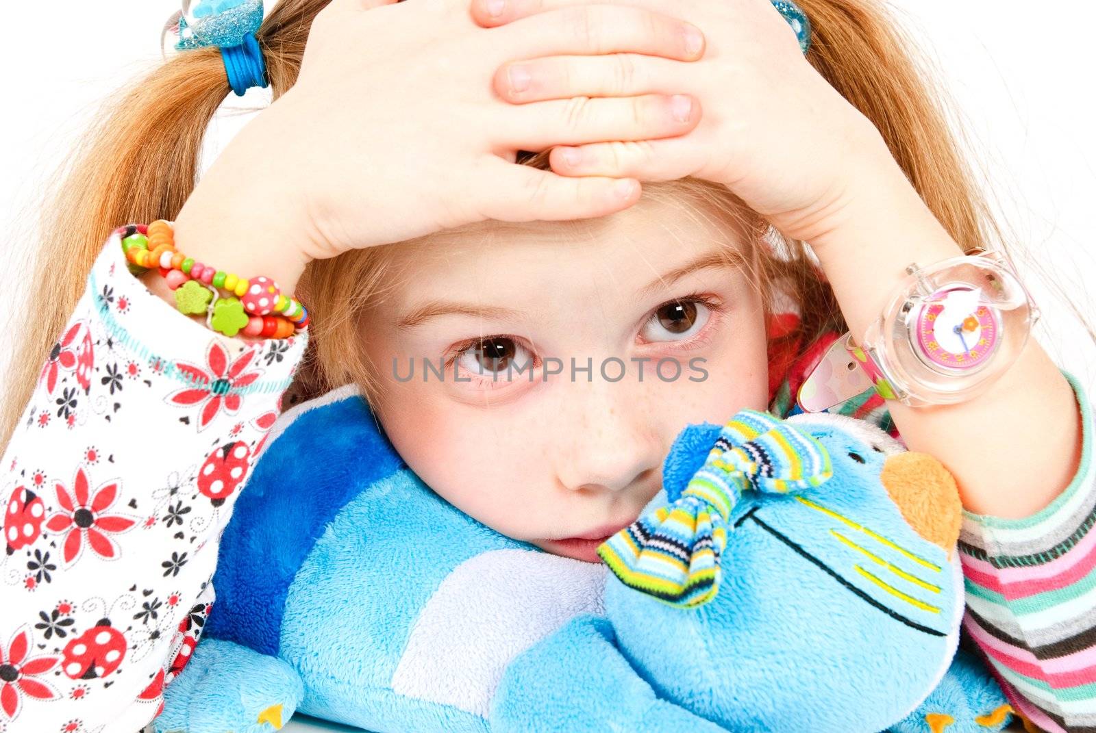 studio shot of sad pretty little girl with blue cat toy