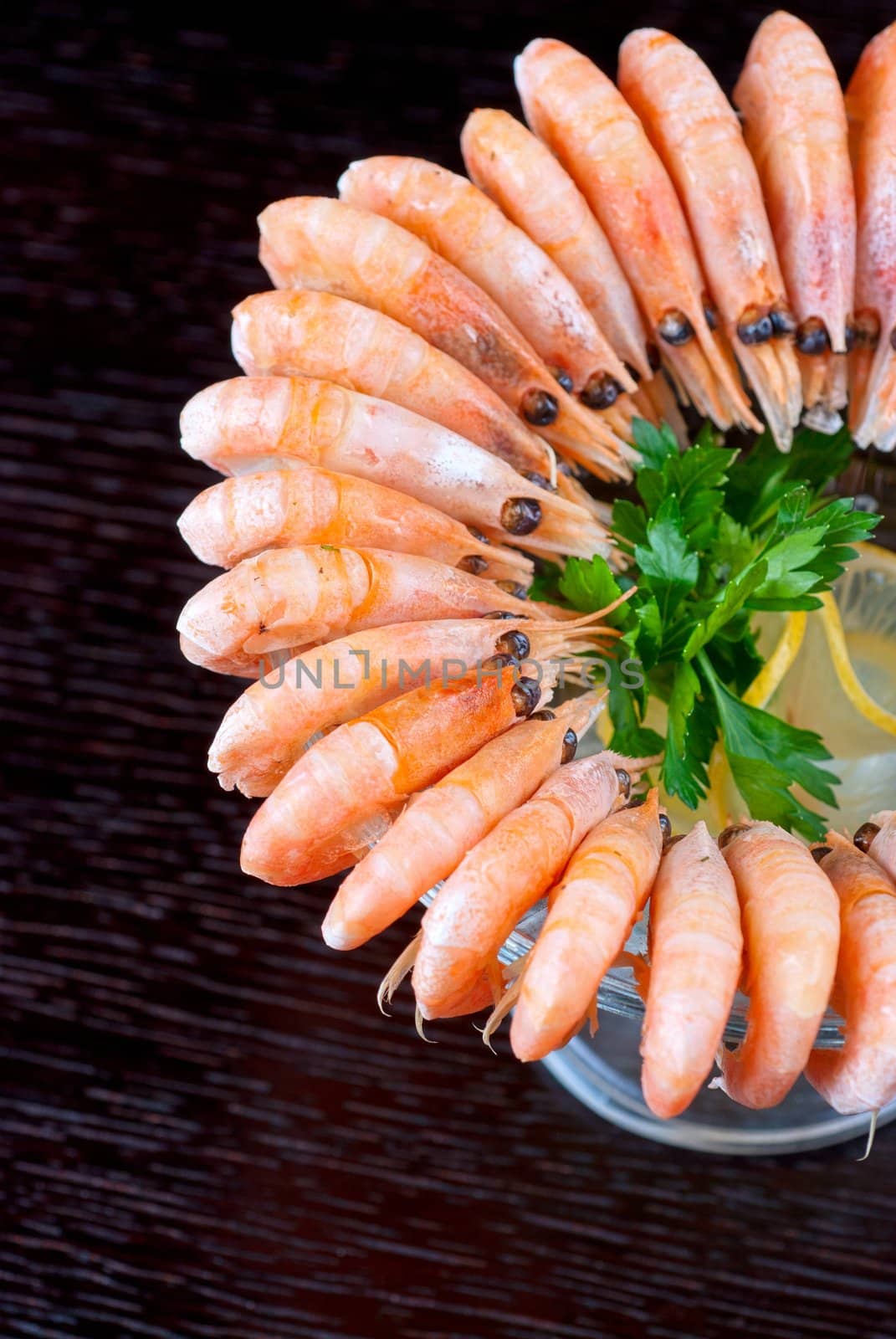 tasty shrimps with lemon and greens closeup