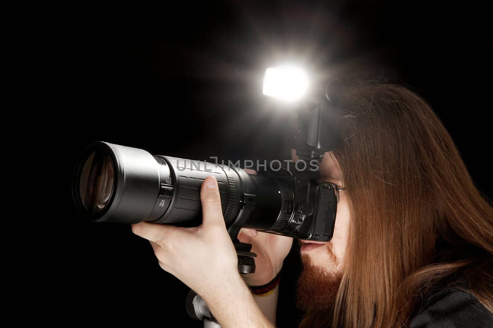 Photographer using DSLR camera with flash and telephoto lens