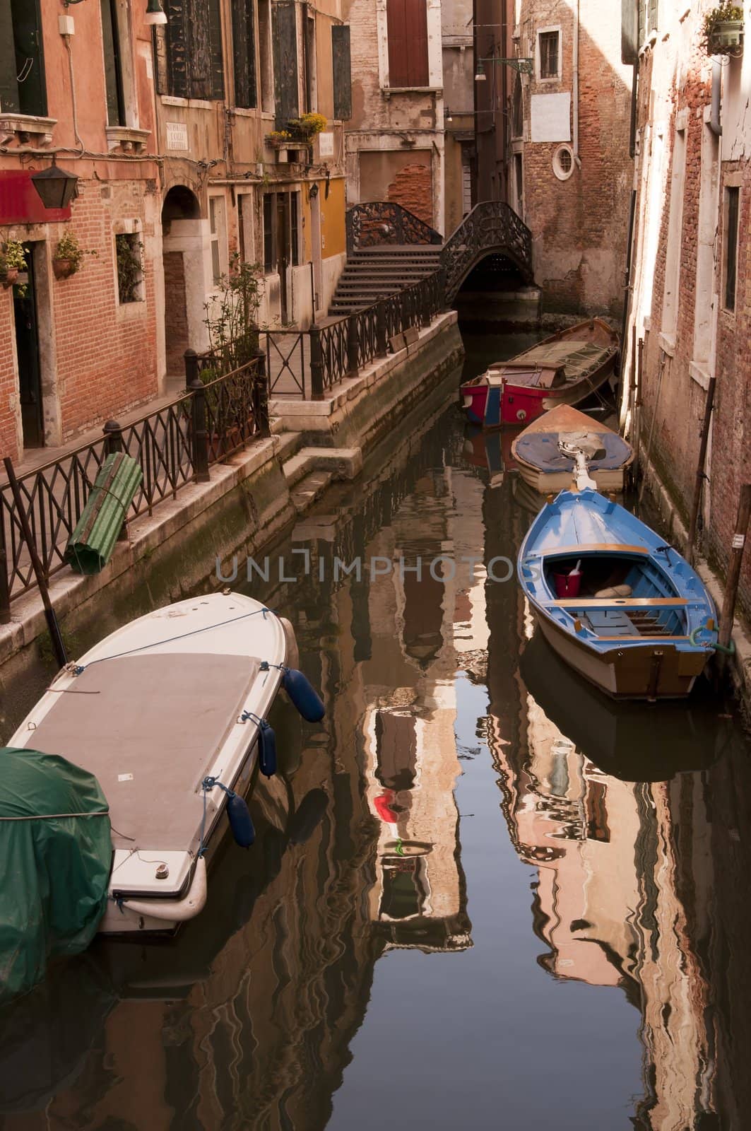 Canal with bridge and boats in Venice, Italy