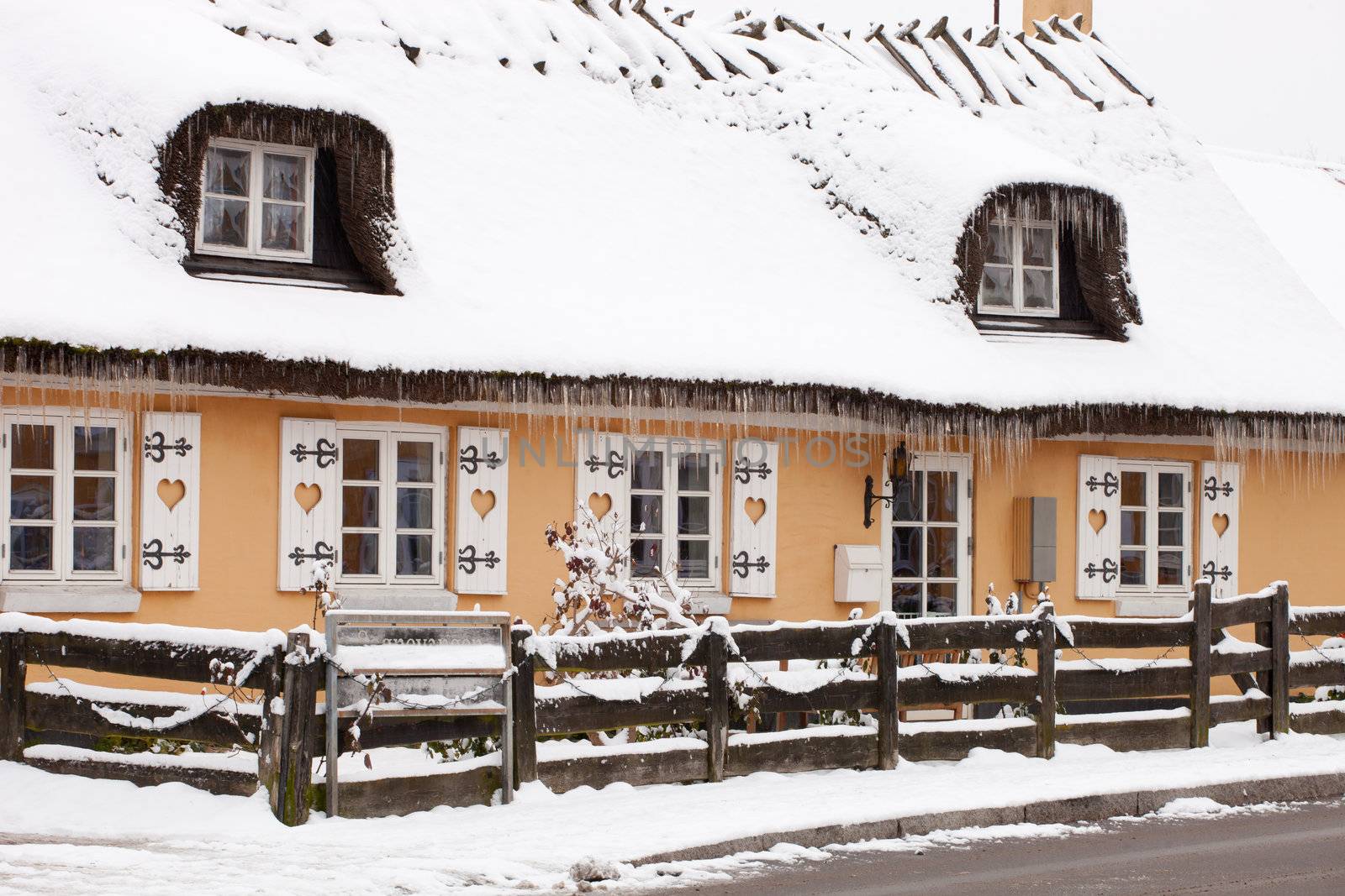 Icicles hanging on a thatched cottage in winter