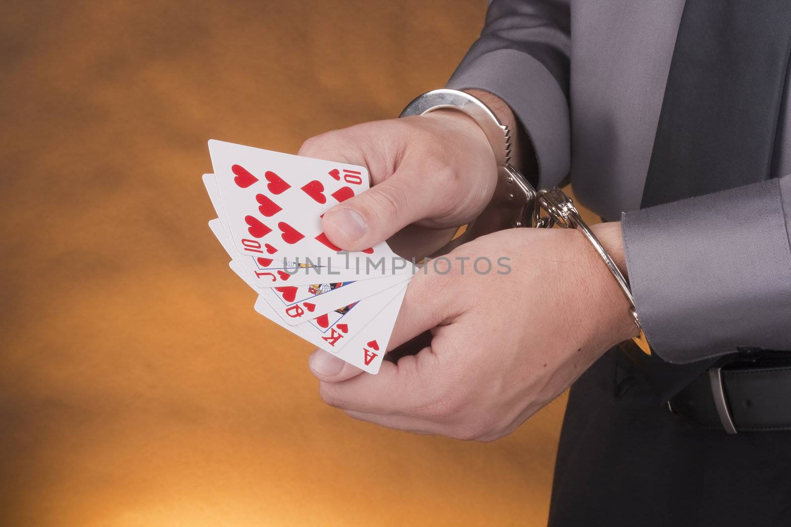 Arrest card sharper, her hands handcuffed in one hand a set of cards in one suit.