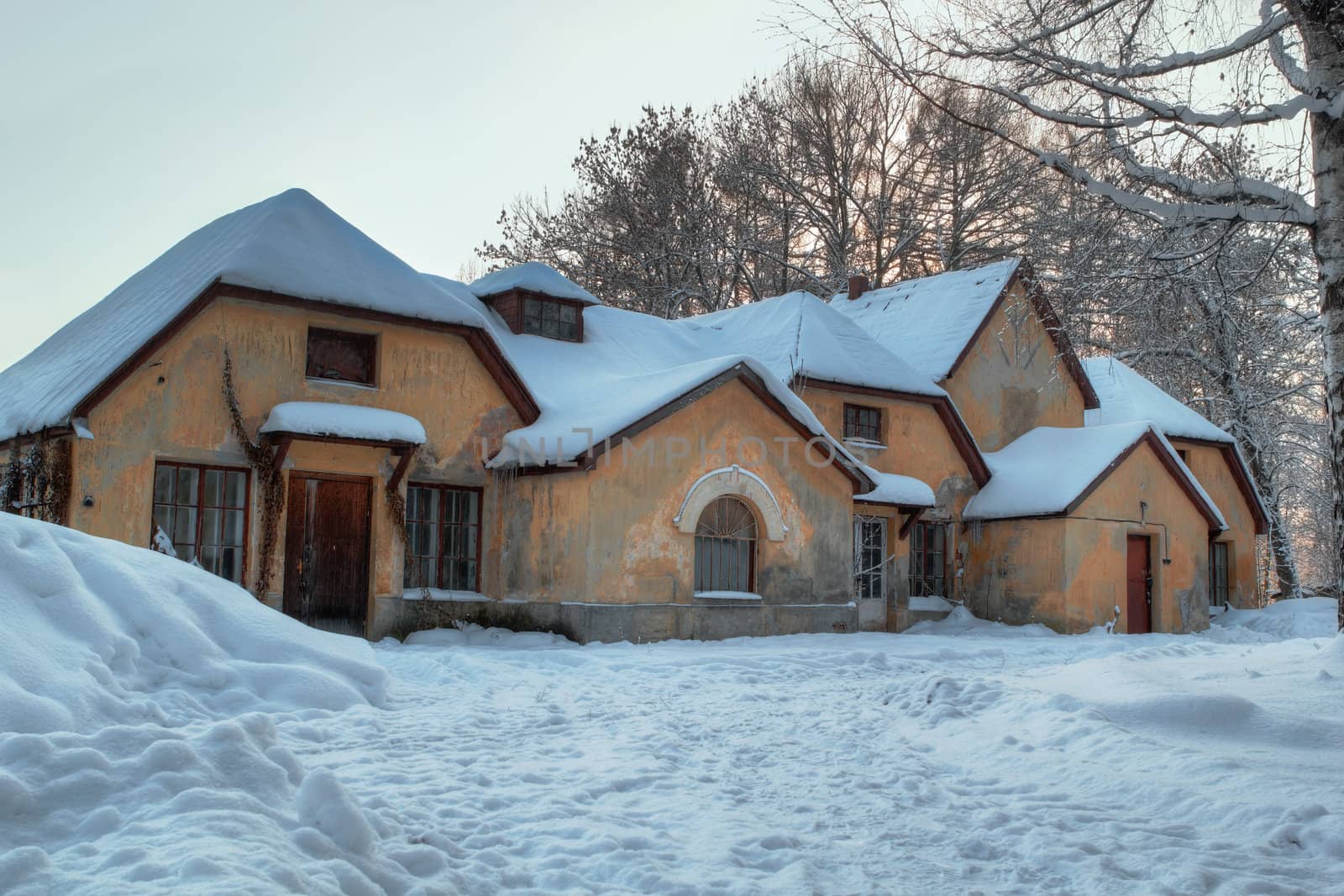 Winter picture of yellow brick house with seven roofs