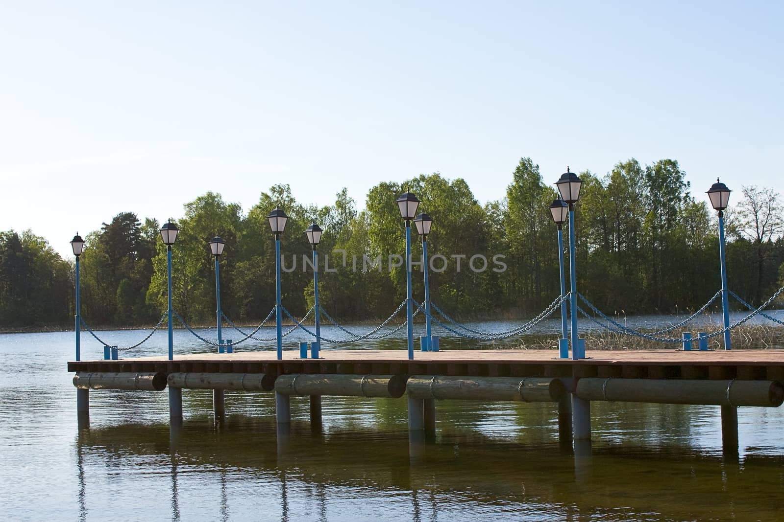 Wooden pier with lanterns on the lake Valdai, Russia.