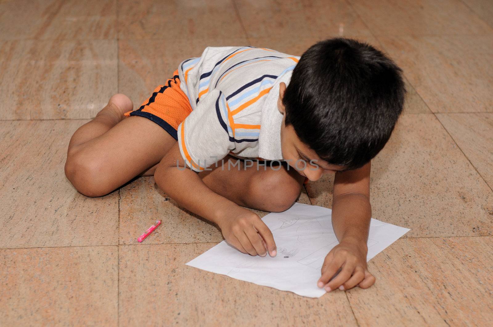 An Handsome Indian boy doing his artwork
