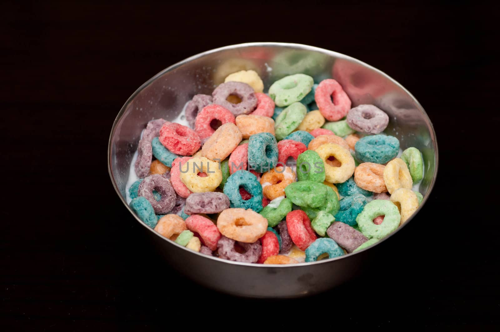 A bowl of looped cerals isolated on black background