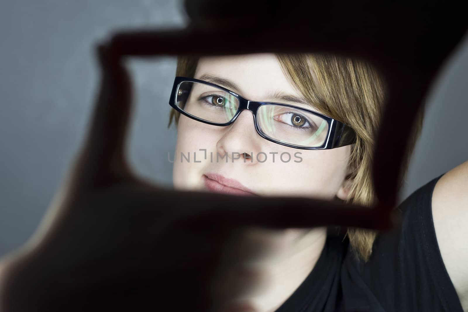 smiling teenage girl making a frame with her hands