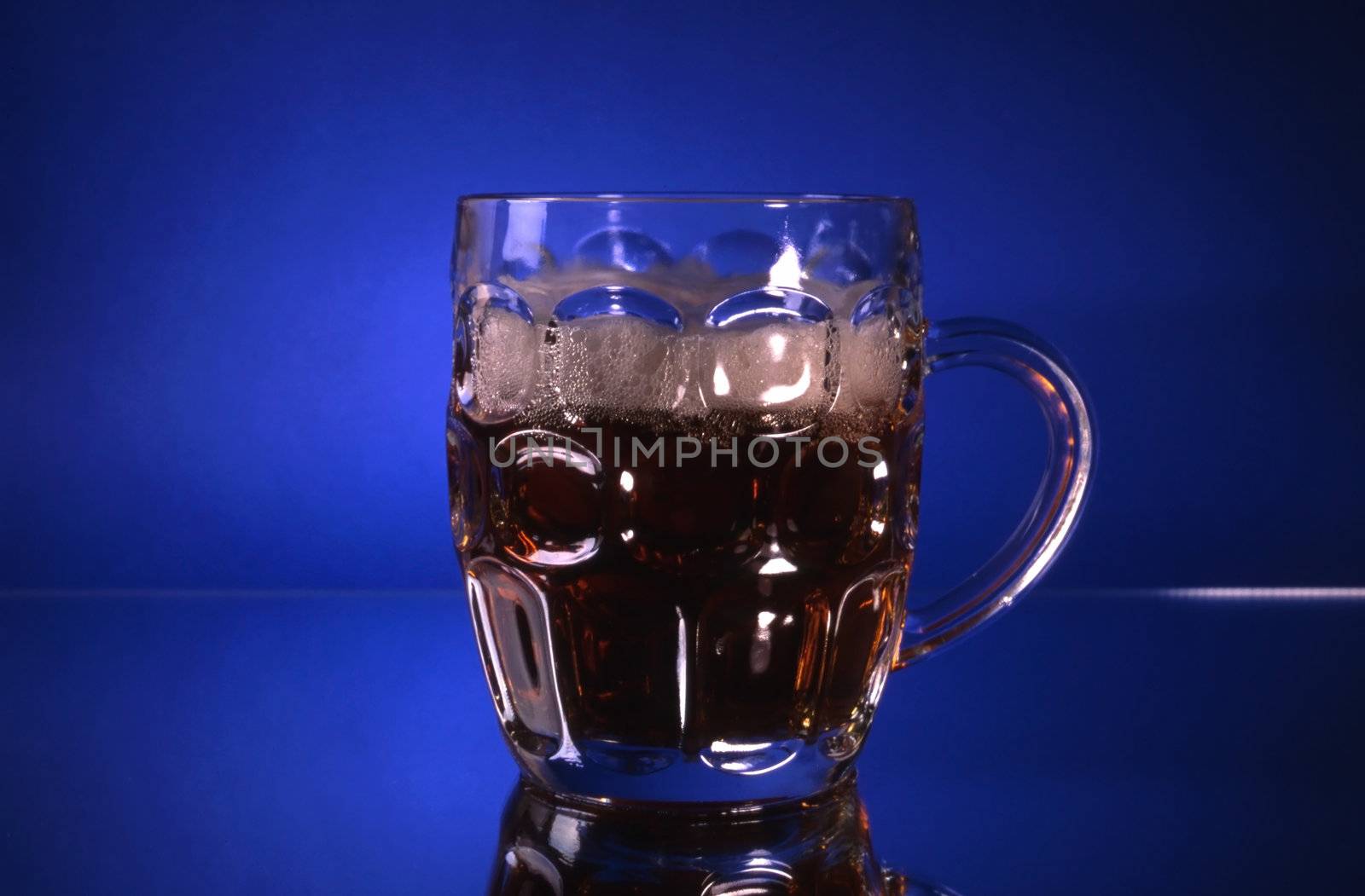 A glass of beer isolated on blue background