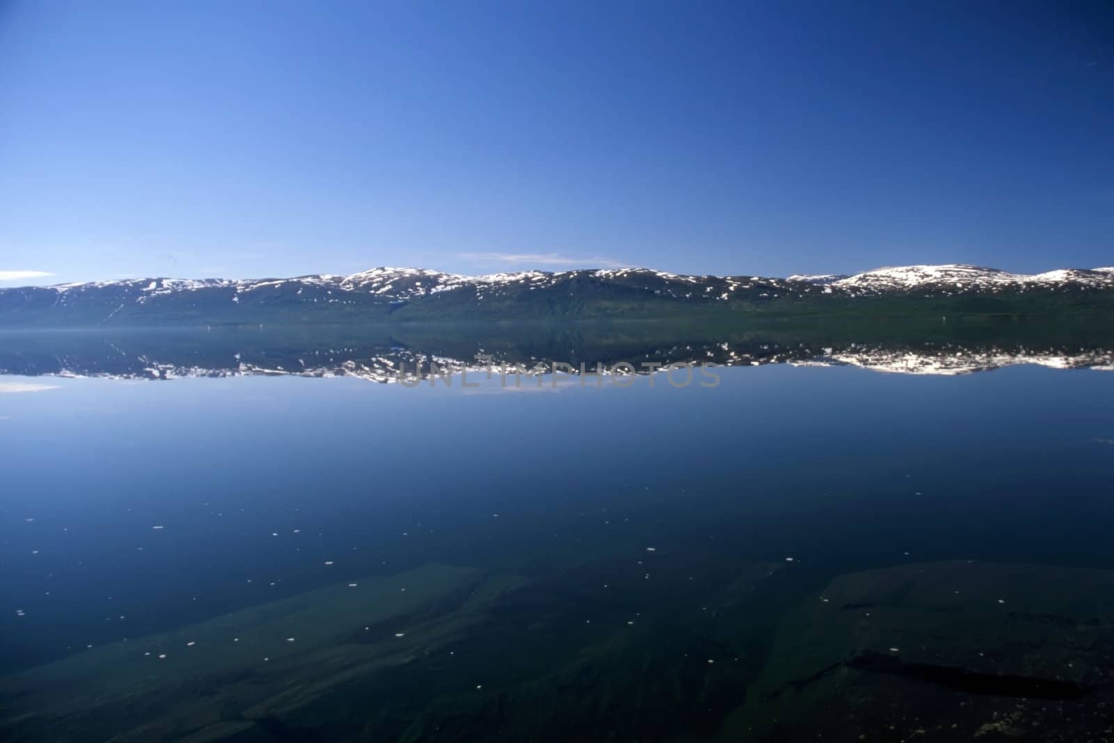 Mirrow lake with snow mountain in Norway